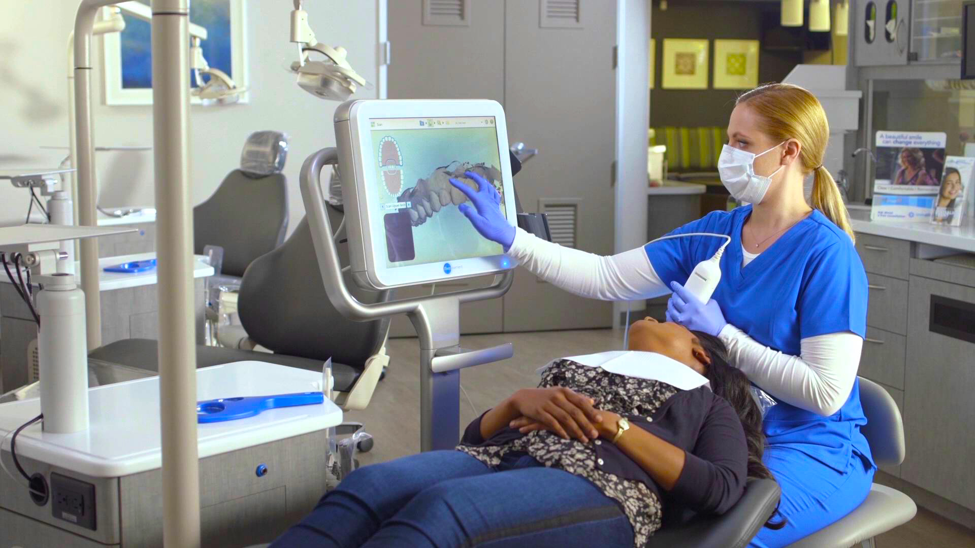 An assistany /orthodontist using the iTero element to scan the teeth of a patient.
