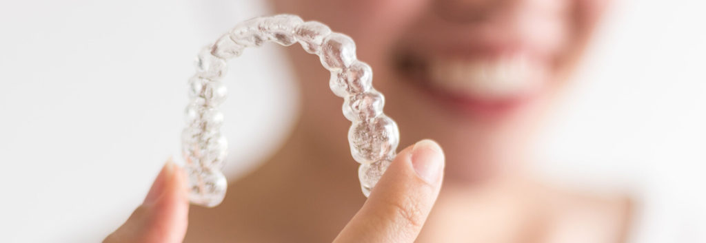 Woman holding her invisalign