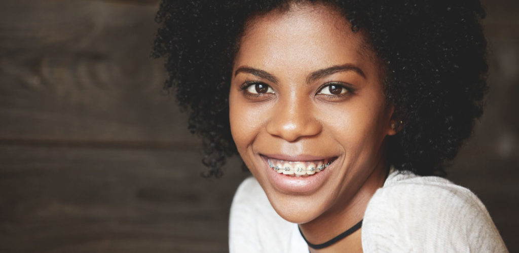 Young woman with braces learning about extra teeth growing in adults