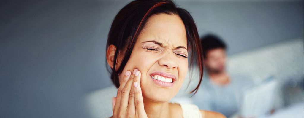 Woman in pain because of teeth grinding