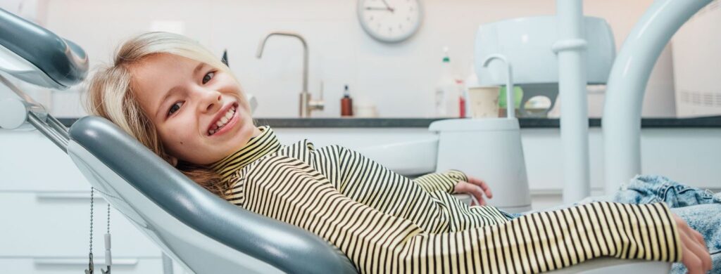 Young patient smiling in orthodontic chair, showcasing comfortable treatment experience at Insoft & Hurst Orthodontics