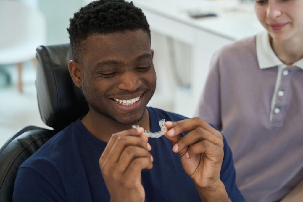 Patient examining Invisalign aligner, exploring Invisalign treatment options in Seminole, FL.