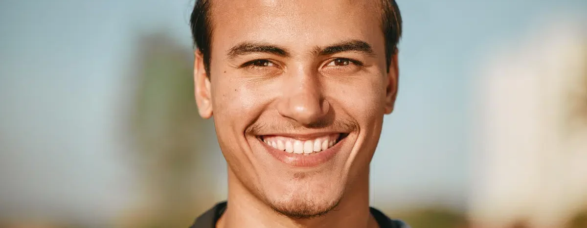 Smiling man showcasing straight, healthy teeth and cosmetic dentistry solutions.